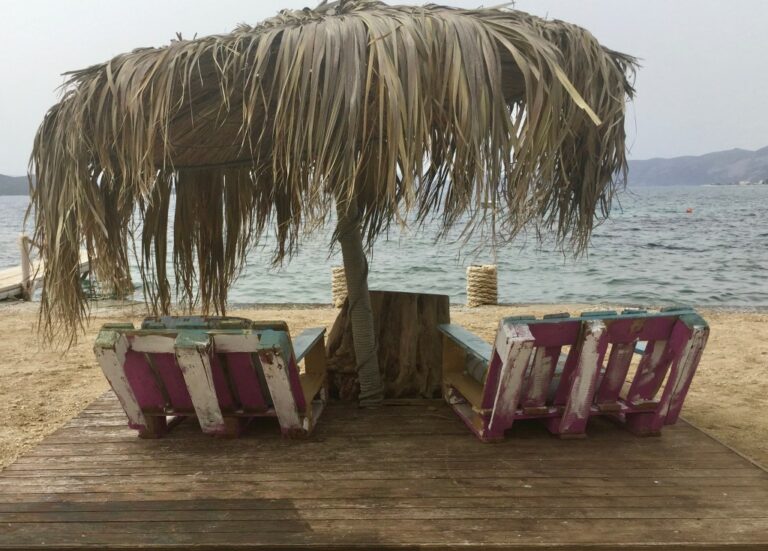 Euböa: Strand am Meer, robuste Liegestühle und Palmenschirm